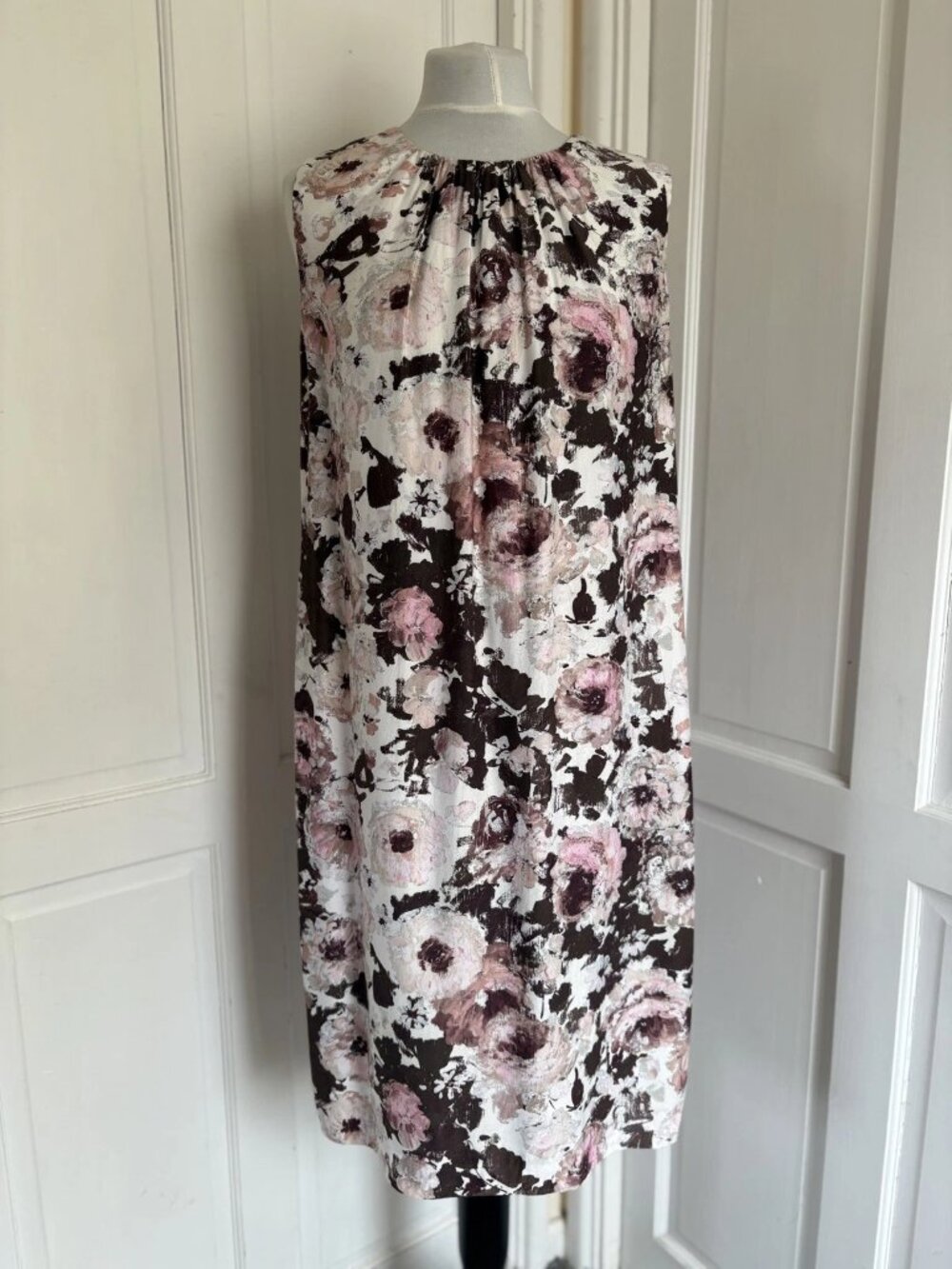 A long silk dress with a floral pattern in red and brown colors